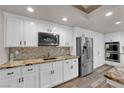 Bright kitchen features custom white cabinets, stainless steel appliances, and eye-catching backsplash at 2901 S Dandelion St, Pahrump, NV 89048