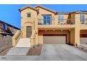 Two-story townhome showcasing a balcony, landscaped front yard and a two car garage at 3898 Blake Canyon Dr, North Las Vegas, NV 89032