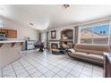 Bright living room with a fireplace, tile floors, and large windows at 4142 Forestville St, North Las Vegas, NV 89032