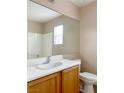 Well-lit bathroom featuring a large mirror, a white countertop, a sink, and a toilet at 5236 El Prado Heights St, North Las Vegas, NV 89081