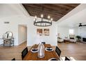 Elegant dining room with a wooden table, modern chandelier, and views into the bright and open living spaces at 5904 Willowcreek Rd, North Las Vegas, NV 89031