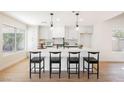 Bright, modern kitchen featuring a center island with bar seating, sleek white cabinetry, and stainless steel appliances at 5904 Willowcreek Rd, North Las Vegas, NV 89031