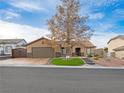 Charming single-story home with desert landscaping, green lawn and a covered entryway at 6627 Bristle Canyon Ave, Las Vegas, NV 89110