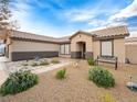 Well-maintained home featuring desert landscaping with a seating bench and a covered entryway at 6627 Bristle Canyon Ave, Las Vegas, NV 89110