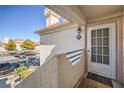 Exterior view of a condo front door with a welcoming 'Welcome' mat and ample parking nearby at 7909 Fossil Creek Ln # 202, Las Vegas, NV 89145