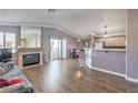 Open-concept living room with fireplace, laminate floors, seamlessly flows into the dining area and modern kitchen at 7909 Fossil Creek Ln # 202, Las Vegas, NV 89145