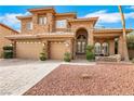 Charming home showcasing a front porch and three-car garage and rock landscaping at 8925 Rio Verde Ave, Las Vegas, NV 89147