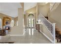 Bright foyer with a staircase, double doors, and glossy tiled floor at 8925 Rio Verde Ave, Las Vegas, NV 89147