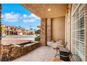 Inviting front porch featuring stone columns, tiled flooring, and a seating area at 8925 Rio Verde Ave, Las Vegas, NV 89147