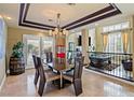 Stylish dining room featuring a modern chandelier, views of game room and access to outdoor space at 9616 Grand Isle Ln, Las Vegas, NV 89144