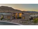 Contemporary home with a desert landscape, stone accents, and a paver driveway at 10096 Amethyst Hills St, Las Vegas, NV 89148