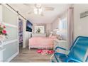 Cozy bedroom with a pink bed, white dresser, ceiling fan, and barn door closet at 1216 Oahu St, Las Vegas, NV 89104