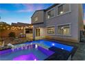 Back exterior of house featuring covered patio with outdoor kitchen and beautiful pool with inset lighting and spa at 201 White Mule Ave, Las Vegas, NV 89148