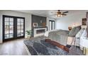 Cozy main bedroom featuring a modern fireplace, stylish accents, and outdoor access at 210 E Longacres Dr, Henderson, NV 89015