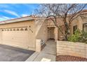 Inviting single-story home with a desert-landscaped yard, tile roof, and two-car garage at 213 N Cimarron Rd, Las Vegas, NV 89145