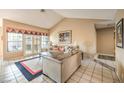 Cozy living room featuring vaulted ceilings, tile floors, large windows, and comfortable seating at 213 N Cimarron Rd, Las Vegas, NV 89145