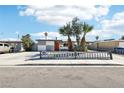 A single-story home with a gray and white checkered paint design and desert landscaping in front at 2205 Santa Clara Dr, Las Vegas, NV 89104