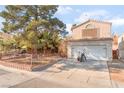 View of a two-story house with a two car garage and decorative rock and fence in the front yard at 2245 Saint Paul Way, Las Vegas, NV 89104