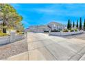 Charming two-story home featuring a light gray exterior, concrete perimeter, and a well-maintained front yard at 241 E Country Club Dr, Henderson, NV 89015