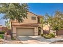 Two-story home features desert landscaping, an attached garage, and neutral stucco at 2653 Rimbaud St, Henderson, NV 89044
