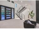 Bright foyer boasts a modern staircase with glass railings and sleek tile flooring at 34 Vintage Canyon St, Las Vegas, NV 89141