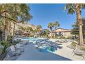 Community pool and spa with lounge chairs surrounded by mature landscaping at 3574 Desert Cliff St # 204, Las Vegas, NV 89129