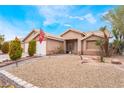 Single story home with a wide driveway, well-kept bushes, rock landscaping, and two-car garage at 4318 Red Blanket Rd, North Las Vegas, NV 89032