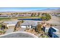 Aerial view of single-story home, golf course frontage, lake, desert landscaping, and mountain views at 4924 E Cactus Canyon Dr, Pahrump, NV 89061