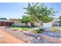 Single-story home featuring a beautiful front yard, mature shade trees, manicured lawn and charming brick wall at 5109 Sugarfoot Ave, Las Vegas, NV 89107
