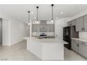 Modern kitchen features a large island, quartz countertops, gray cabinets, and stainless steel appliances at 5147 Stonecrop St, North Las Vegas, NV 89031