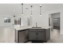 The modern kitchen overlooks the open floor plan and features a large center island with quartz countertops at 5147 Stonecrop St, North Las Vegas, NV 89031