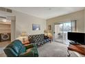 Living room featuring sliding glass doors, a television, sofa and cozy chair at 5751 E Hacienda Ave # 172, Las Vegas, NV 89122