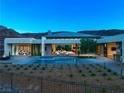 Backyard view of modern home with a pool overlooking mountains during dusk sky at 6 Rockmount Ct, Henderson, NV 89012