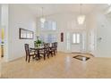 Bright dining room with modern chandeliers, plantation shutters, and elegant tile flooring at 6120 Farm Rd, Las Vegas, NV 89131