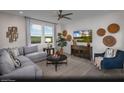 A living room area features neutral tones, a ceiling fan, and a large window with scenic views at 6668 Nimbus Ave # Lot 22, Las Vegas, NV 89130