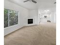 Bright and airy living room featuring a fireplace, a large window, and neutral carpet at 6701 Squaw Mountain Dr # 201, Las Vegas, NV 89130