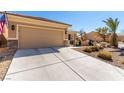 Home featuring a two-car garage with desert landscaping and a well-kept lawn at 7640 Fieldfare Dr, North Las Vegas, NV 89084
