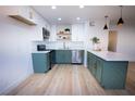 Modern kitchen with white and green cabinets, stainless steel appliances and a spacious marble countertop at 7932 Diamond Rock Way # 101, Las Vegas, NV 89128