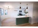 Stylish kitchen with white and green cabinets, stainless steel appliances and ample counter space at 7932 Diamond Rock Way # 101, Las Vegas, NV 89128
