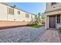 Wide shot of a backyard showcasing a gray paved patio with artificial turf grass at 9085 Bridal Creek Ave, Las Vegas, NV 89178