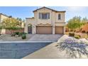 Exterior shot of a stucco two-story home with two-car garage, desert landscaping, and arched entry at 9085 Bridal Creek Ave, Las Vegas, NV 89178