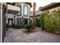 The beautiful courtyard features pavers, a mature palm and flowering plants at 9325 Canyon Classic Dr, Las Vegas, NV 89144