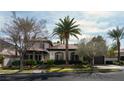 An elegant home surrounded by mature palm trees, green lawns, and desert landscaping at 9325 Canyon Classic Dr, Las Vegas, NV 89144