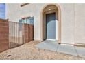 Inviting front entrance with a stylish blue door and an arched entryway at 9881 Juno Hills St, Las Vegas, NV 89178