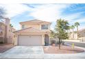 Charming two-story home featuring a tile roof, well-kept lawn, and an attached two-car garage at 1653 Sun Canyon Ct, Las Vegas, NV 89128