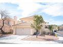 Inviting two-story home with a tile roof, two-car garage, and nicely landscaped front yard at 1653 Sun Canyon Ct, Las Vegas, NV 89128