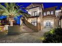 Elegant facade featuring a curved staircase ascending to a stylish entrance with double doors and stone accents at 30 Via Tiberius Way, Henderson, NV 89011