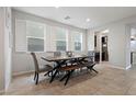 Dining area featuring stylish table and chairs, complemented by natural light from shuttered windows at 4519 Stardusk Falls Ave, North Las Vegas, NV 89084