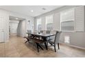 Bright dining room with a wooden table, bench, and chairs, illuminated by natural light at 4519 Stardusk Falls Ave, North Las Vegas, NV 89084
