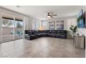 Spacious living room with a large sectional sofa, ceiling fan, and sliding glass doors at 4519 Stardusk Falls Ave, North Las Vegas, NV 89084